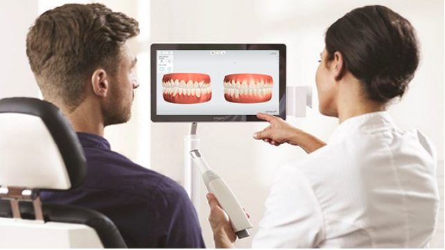 Dentist and patient reviewing images of teeth produced by trios scanner