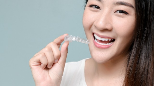 Smiling woman enjoying the benefit of Invisalign orthodontic treatment