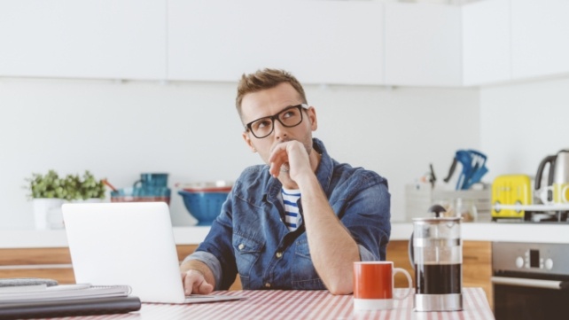 Man sitting at desk looking pensive