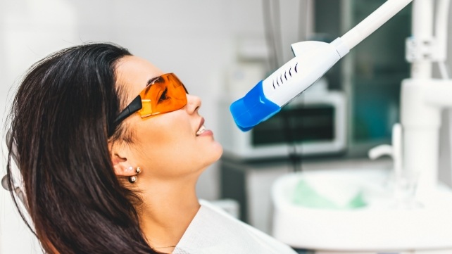 Woman in dental chair receiving teeth whitening