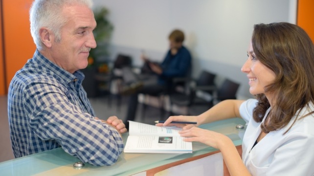 Dental team member and patient talking at front desk