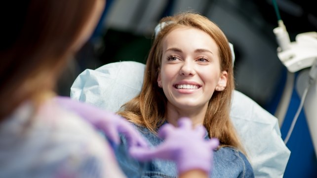 Woman with perfectly aligned smile after Invisalign clear braces treatment