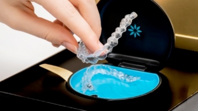 Patient placing Invisalign trays in carrying case