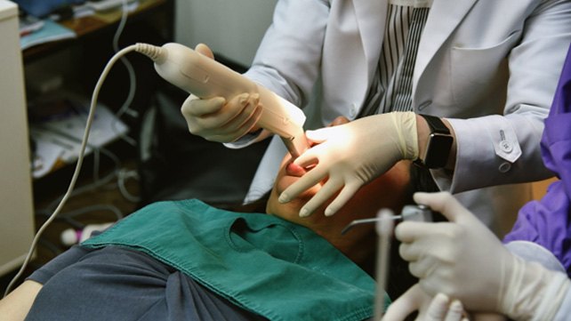 Dental patient having their teeth scanned with iTero