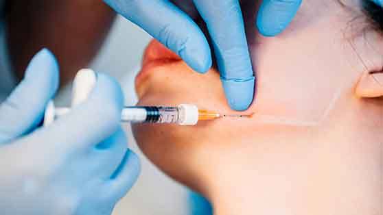 Woman receive BOTOX injection in her jaw