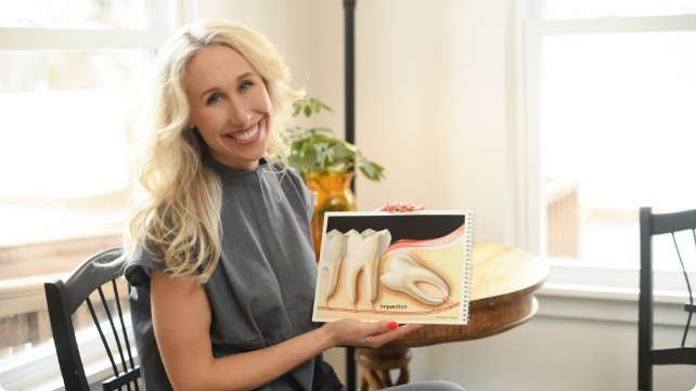 Doctor Kristen holding a tooth model