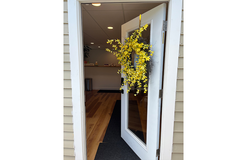 Open front door with yellow wreath