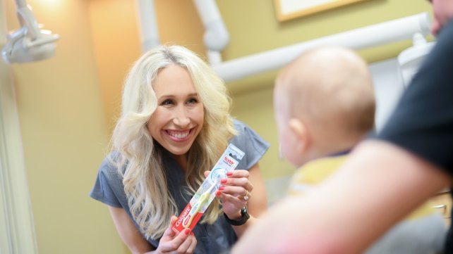 Dentist smiling at child during children's dentistry visit