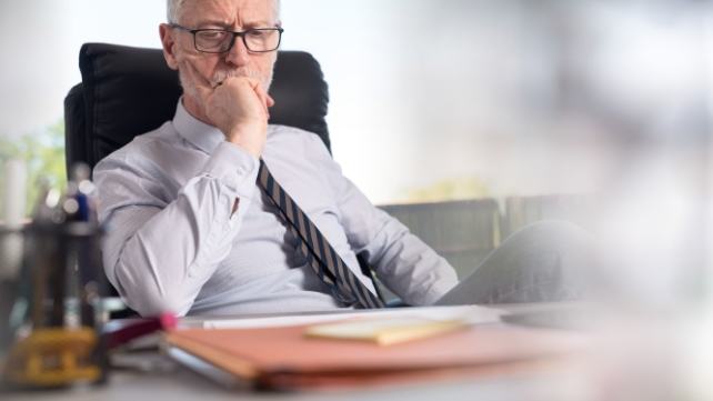 Man at office desk looking pensive