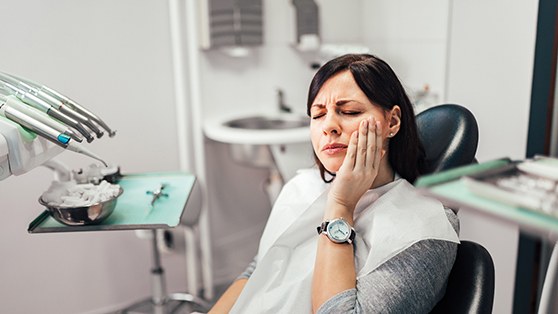 A dentist pointing to the TMJ on a model skull