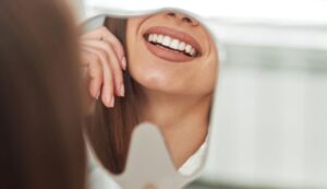 Dental patient looking at her teeth in mirror 