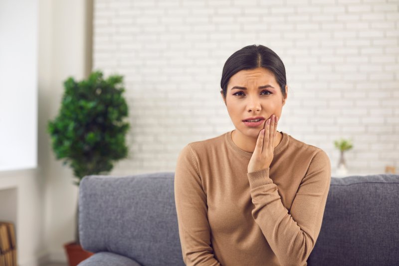 Patient with TMJ disorder holding jaw